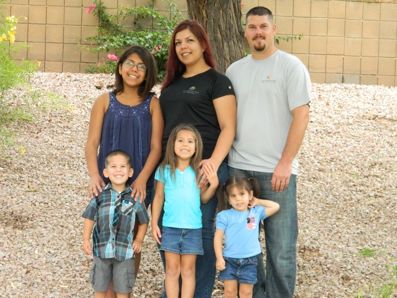 Kris, his wife and their kids standing together outdoors, from when the company started